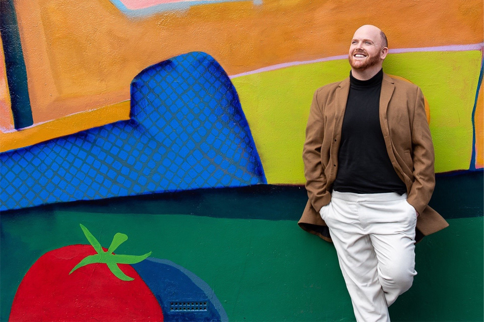 Man leaning on a colourfully painted wall